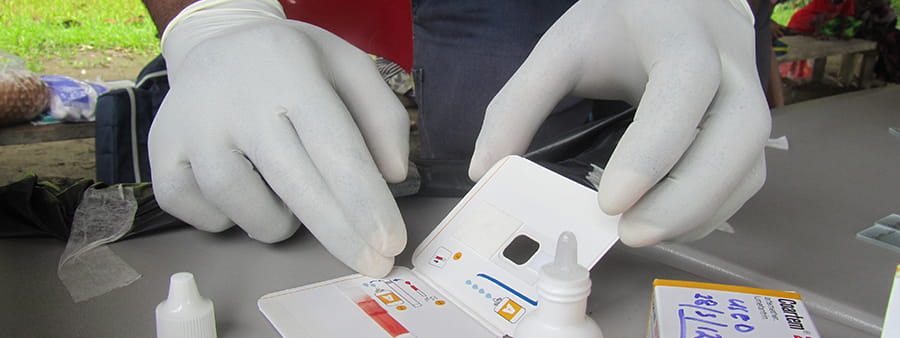 Close up of malaria treatment with white gloves